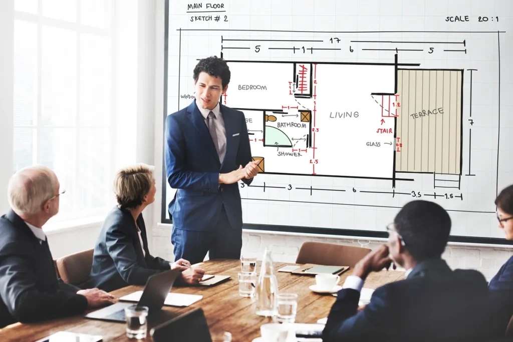 Profissional apresentando um projeto arquitetônico detalhado para colegas em uma reunião empresarial