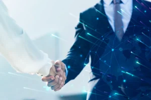 Aperto de mãos entre profissionais em terno, com gráficos digitais e representação de um globo ao fundo, simbolizando parceria e networking global.
