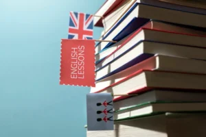 Pilha de livros com marcadores visuais, incluindo uma bandeira do Reino Unido e um marcador com a inscrição "English Lessons"