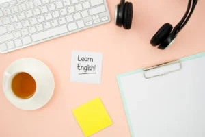 Mesa de estudo com teclado, fones de ouvido, anotações motivacionais e uma xícara de chá