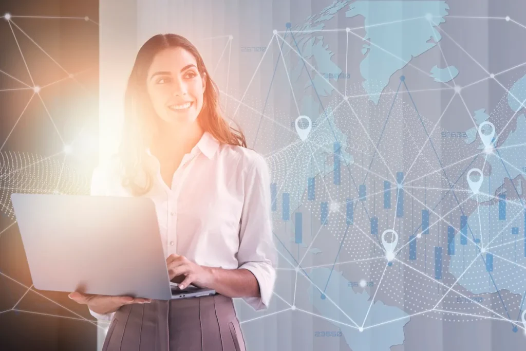 Imagem de uma mulher profissional sorrindo enquanto segura um laptop, com gráficos e mapas digitais conectando pontos ao redor do mundo. A cena representa o impacto da conectividade global e análise de dados em um ambiente de negócios.