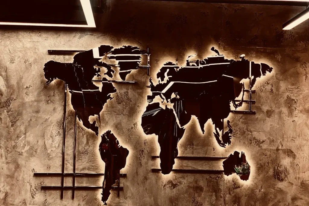 Mapa-múndi iluminado em uma parede, simbolizando a presença global de multinacionais.
