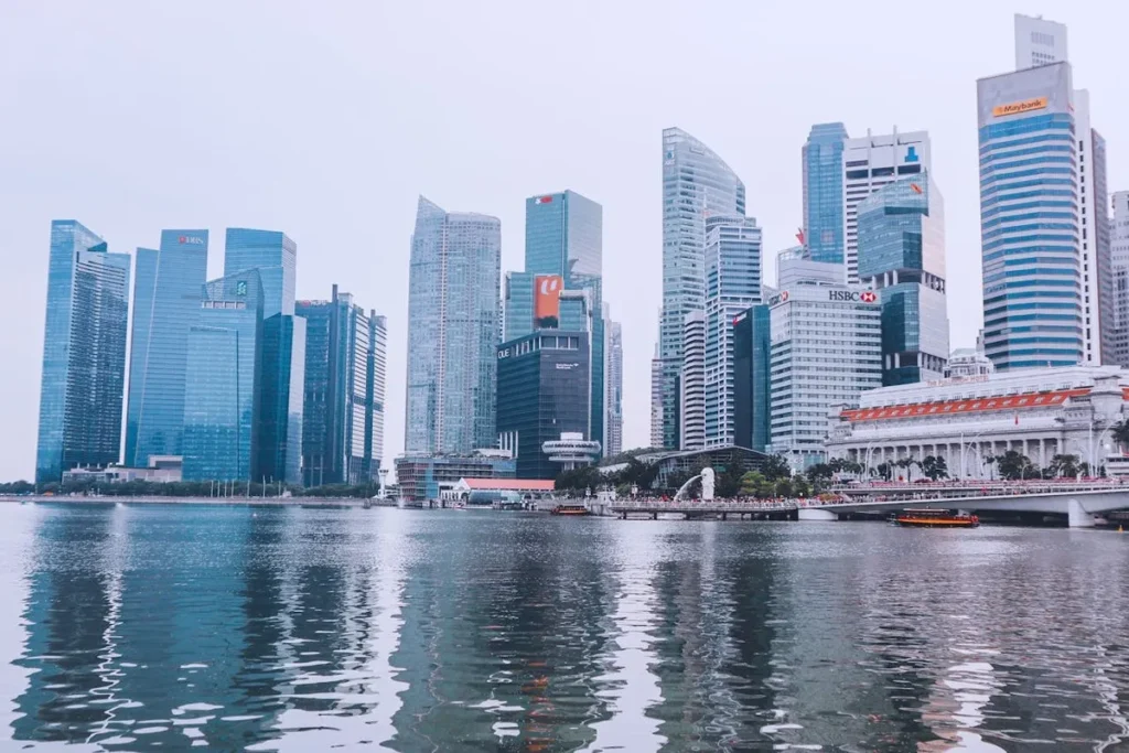 Skyline de Singapura com prédios de vidro de grandes multinacionais como HSBC, Maybank e DBS Bank, representando o centro financeiro da Ásia.