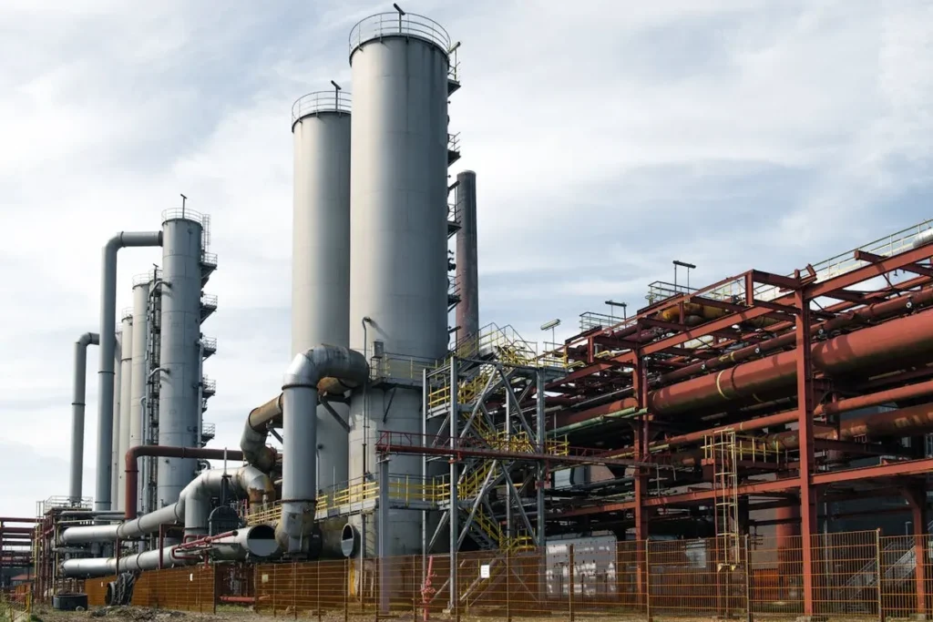 Torres de processamento, tubos e estruturas metálicas em uma usina siderúrgica.
