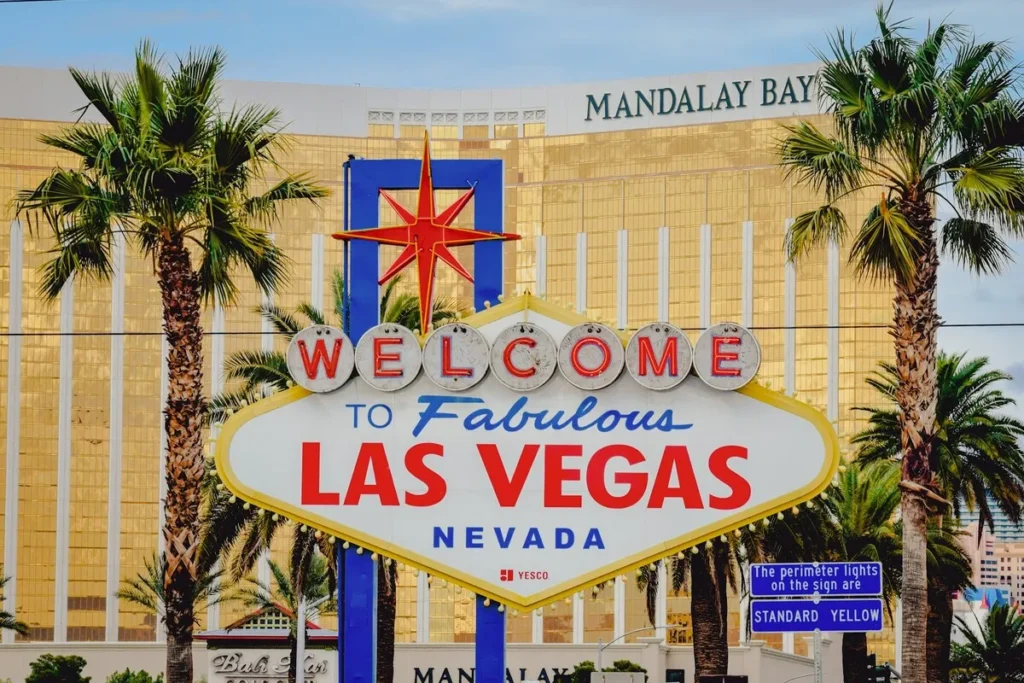 Placa "Welcome to Fabulous Las Vegas Nevada" com o hotel Mandalay Bay ao fundo.