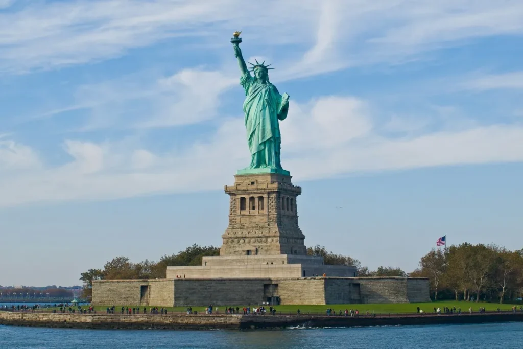Estátua da Liberdade em Nova York vista de longe em um dia claro e ensolarado.