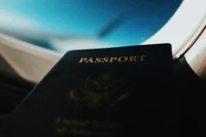 Passaporte dos Estados Unidos em destaque com janela de avião ao fundo mostrando céu azul