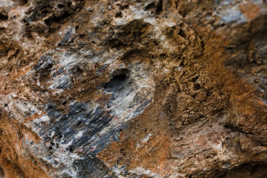 Textura detalhada de uma rocha vulcânica com diversas cores e porosidades, revelando aspectos da geologia.