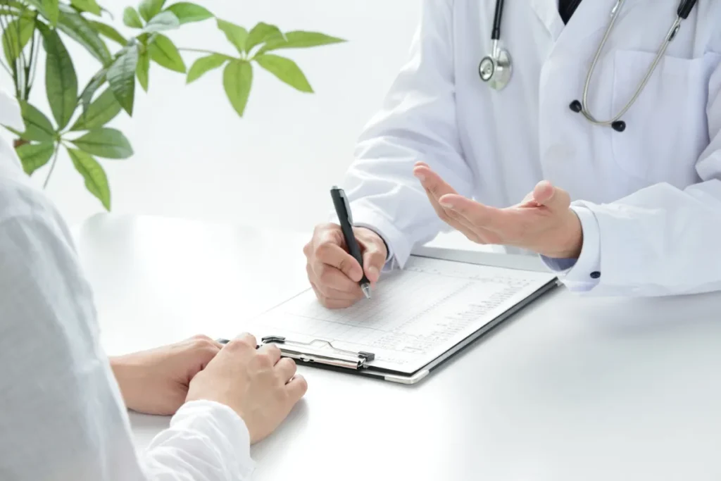 Triagem em inglês. Médico anotando informações em prancheta durante atendimento de paciente